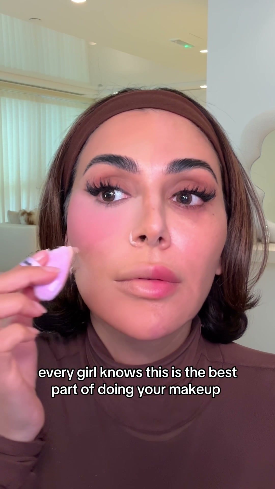 Huda Beauty ad: Working the under-eye with a sponge, on camera.