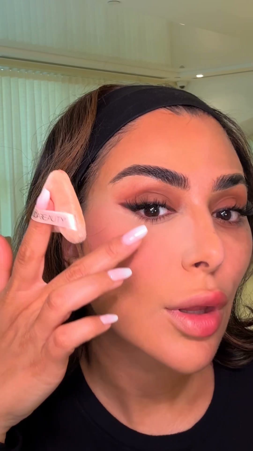 Huda Beauty ad: An under-eye being set, on camera.